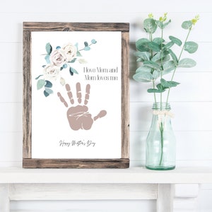 May include: A framed print with a handprint and floral design. The text reads "I love Mom and Mom loves me. Happy Mother's Day."