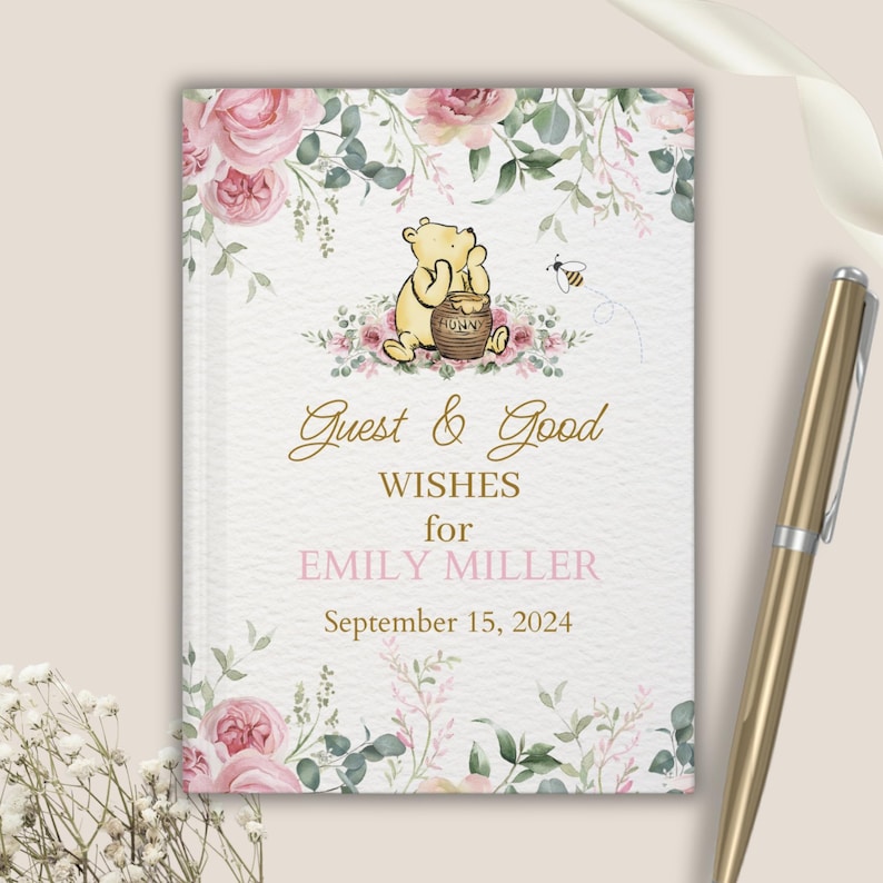 May include: A Winnie the Pooh themed guest book with a floral design. The cover features Winnie the Pooh holding a honey pot with the text "Guest & Good Wishes for Emily Miller September 15, 2024".