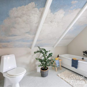 May include: A bathroom with a ceiling mural depicting a cloudy sky. The room features a white toilet, a bathtub, and a potted plant. The floor is tiled, and the walls are painted a neutral color. The text "Vintage Murals" is visible.