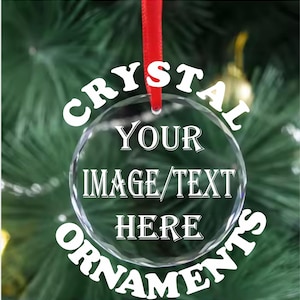 May include: A clear glass Christmas ornament with the text "CRYSTAL ORNAMENTS" around the edge and "YOUR IMAGE/TEXT HERE" in the center. The ornament is hanging from a red ribbon.