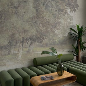 May include: A green modular sofa with a wooden coffee table and a vase of green plants in front of a wall mural depicting a forest scene. The coffee table has a magazine on top. The text "Bosco Murals" is visible in the bottom left corner of the image.