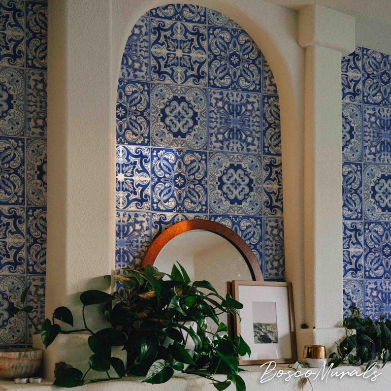 May include: A white wall with a blue and white patterned tile mural. The mural is in an arched alcove with a mirror and a plant in front of it. The text "Bosco Murals" is at the bottom of the image.