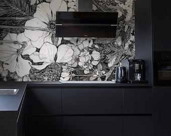 May include: Black and white floral wallpaper mural in a modern kitchen with black cabinets and a black range hood. The wallpaper features large, detailed flowers and leaves.
