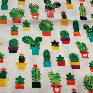 May include: A white fabric with a repeating pattern of green cacti in colorful pots. The cacti are in various shapes and sizes, including some with multiple arms.