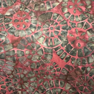 May include: Red fabric with a repeating pattern of dark gray, circular designs. The designs are made up of small, geometric shapes.