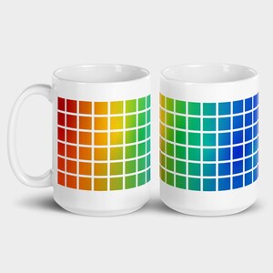 May include: Two white ceramic mugs featuring a rainbow gradient pattern. The design is a grid of squares that shift from red to orange, yellow, green, blue, and indigo.