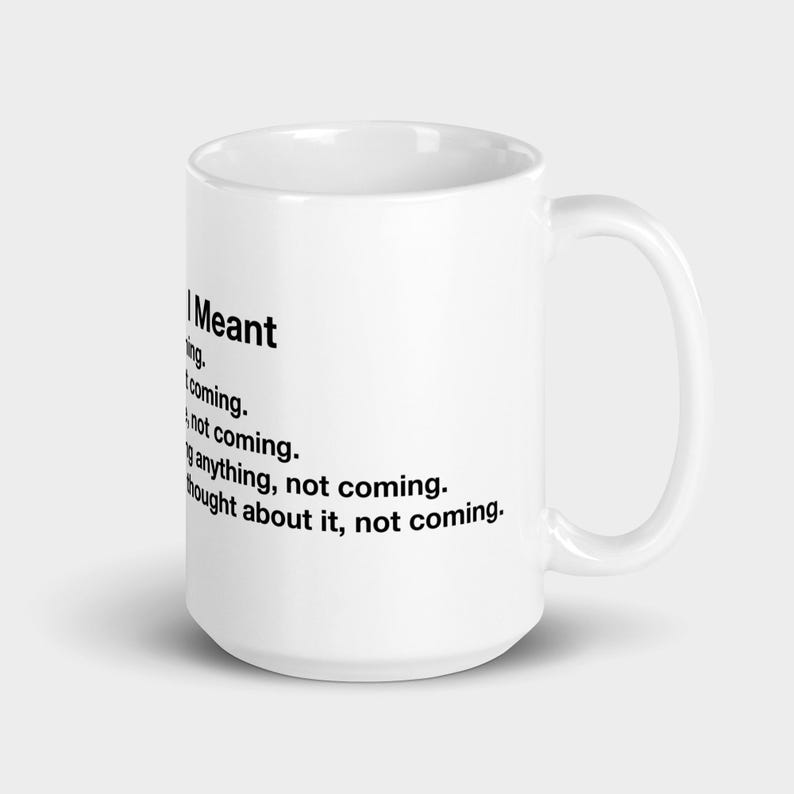 May include: White ceramic coffee mug with the text "I Meant" followed by a list of phrases in black font. The mug has a curved handle and a glossy finish. A humorous gift idea.