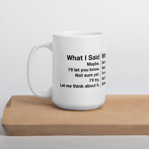 May include: White ceramic mug with black text that reads "What I Said" followed by a list of responses. The mug is on a wooden tray. The mug has a large handle.