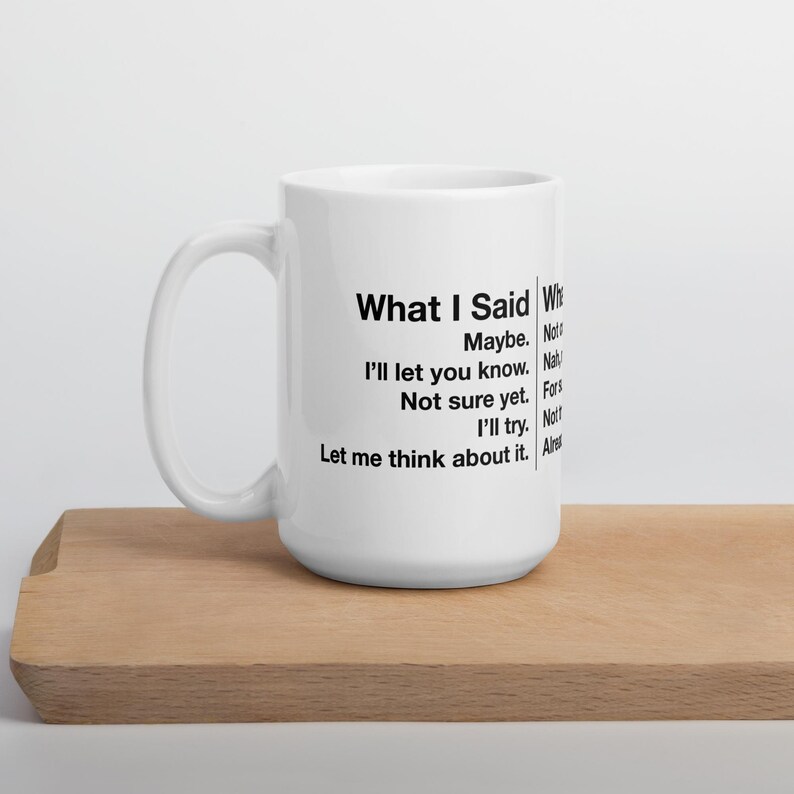 May include: White ceramic mug with black text that reads "What I Said" followed by a list of responses. The mug is on a wooden tray. The mug has a large handle.
