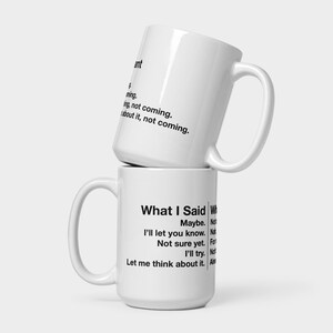 May include: Two white ceramic mugs stacked on top of each other. The top mug has text that reads "ant, ming, ing, not coming, about it, not coming." The bottom mug has text that reads "What I Said, Maybe, I'll let you know, Not sure yet, I'll try, Let me think about it."