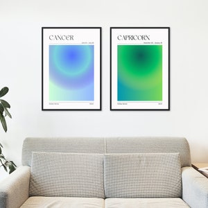 May include: Two framed posters with a gradient background. The poster on the left is blue and green and says "CANCER June 21 - July 22". The poster on the right is green and yellow and says "CAPRICORN December 22 - January 19".