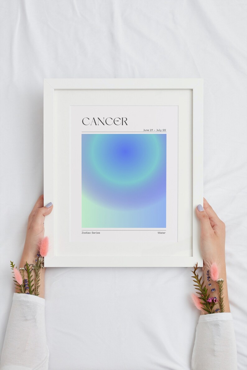 May include: A white framed print with a blue and green gradient design. The print features the word "CANCER" in black text and the dates "June 21 - July 22". The text "Zodiac Series" and "Water" are also included.