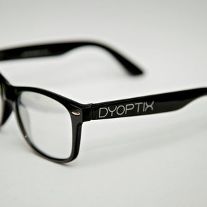 May include: Black plastic framed glasses with clear lenses. The glasses have the word "DYOPTIX" printed on the side.