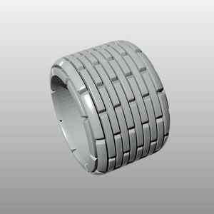 Può includere: Un oggetto cilindrico grigio con una superficie testurizzata. L'oggetto è composto da una serie di forme rettangolari impilate.