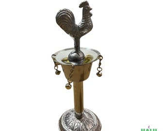 Può includere: Lampada a olio in metallo argentato e dorato a forma di gallo con base rotonda e campanelle pendenti.