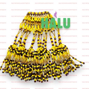 May include: A beaded necklace with a gold and yellow fringe. The necklace is made of small, round beads in shades of gold, yellow, and brown. The fringe is made of strands of beads that hang down from the necklace.