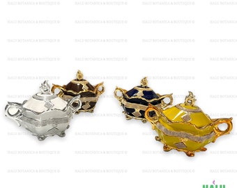 Pode incluir: Quatro taças decorativas com tampa e duas alças, com acabamento brilhante em prata, castanho escuro, azul marinho e amarelo. Cada taça é adornada com uma faixa central de pequenos cristais cintilantes e um detalhe de cristal em forma de losango.