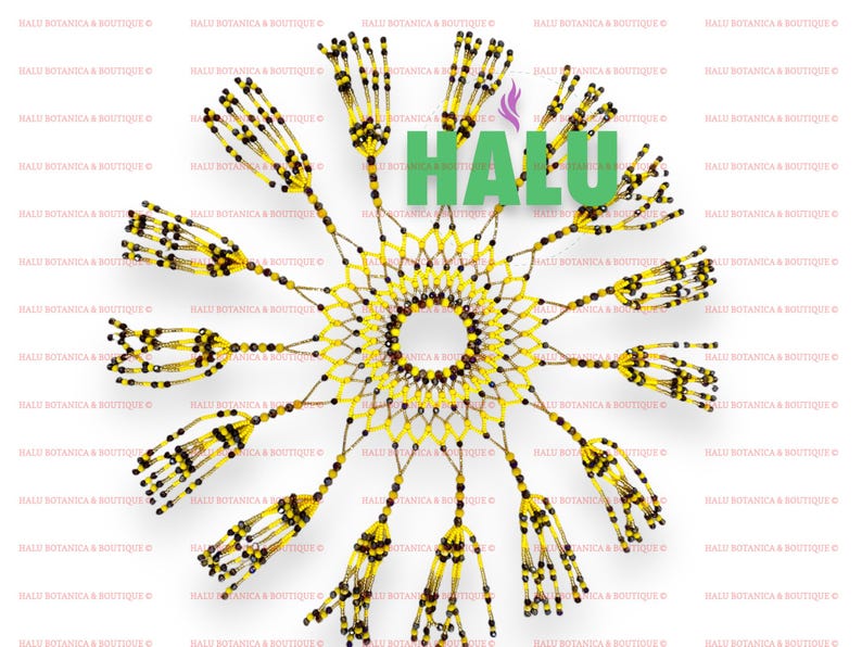May include: A yellow and brown beaded sun catcher with a circular design and fringe. The sun catcher is made of small beads and has a woven pattern. The word "HALU" is visible in the center of the sun catcher.