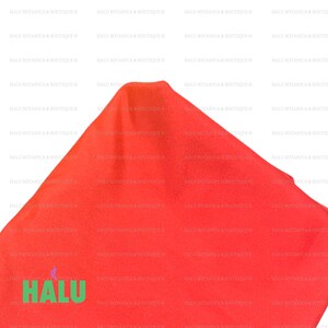 May include: A bright red fabric with the word "HALU" printed in green letters on the bottom left corner.