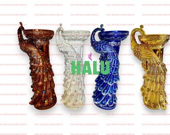 Puede incluir: Cuatro candelabros decorativos con forma de pavo real. Los candelabros están hechos de cerámica y están pintados en diferentes colores: dorado, blanco, azul y marrón. Cada candelabro tiene una parte superior redonda para una vela y un diseño de cola de pavo real.