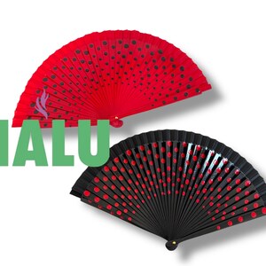 Peut inclure: Deux éventails à main, un rouge à pois noirs et l'autre noir à pois rouges. Le mot "HALU" est en lettres vertes devant les éventails.