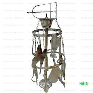 May include: A silver metal stand with a round top and three legs. The stand has a variety of metal tools hanging from it, including a spatula, a whisk, a ladle, and a few other kitchen utensils.