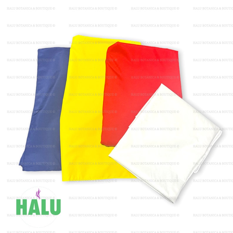 May include: Three fabric squares in blue, yellow, and red. The squares are folded and arranged on a white surface. The word "HALU" is printed in green on the surface.