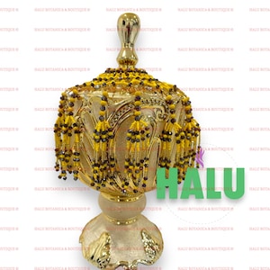 May include: A gold decorative stand with a round top and three legs. The stand is adorned with yellow and brown beaded tassels.