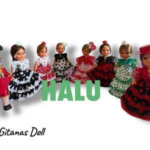 Op de afbeelding: Een verzameling van 24 cm Gitana poppen, elk gekleed in kleurrijke flamenco kleding. De poppen dragen jurken met stippen, ruches en kant, in rood, zwart en wit. Eén pop is gekleed als een stierenvechter.