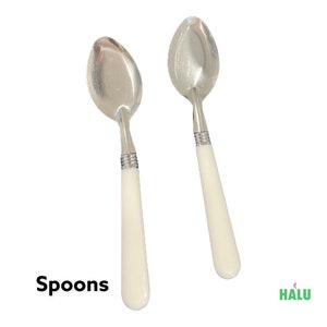 May include: Two white handled spoons with silver metal bowls. The spoons are arranged side by side on a white background. Spoons.