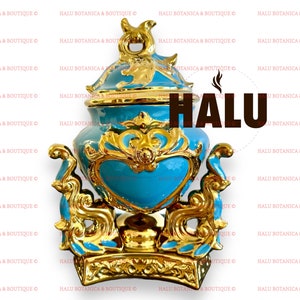 May include: A decorative teal and gold urn with ornate detailing. The urn features a heart-shaped design and is embellished with gold accents. The word "HALU" is visible on the image. The urn is likely used for decorative purposes.