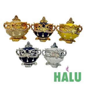Può includere: Cinque ciotole decorative con coperchio in oro, blu navy e giallo, con decorazioni floreali e di cristallo ornate. Le ciotole hanno manici e poggiano su basi decorative. Il logo "HALU" è nell'angolo in basso a destra.