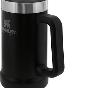 May include: Black Stanley beer stein with a silver rim and handle. The Stanley logo is visible on the front. The mug is made of stainless steel and has a large, sturdy handle.