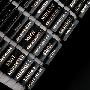 以下が含まれることがあります： 金箔の文字が施された黒い聖書用インデックスタブのセット。タブには、マタイ、マルコ、ルカ、ペテロの手紙一、テモテへの手紙一、ガラテヤ人への手紙、ゼパニヤ書、ハバクク書、コリント人への手紙二、テサロニケ人への手紙二、ヤコブの手紙、ユダの手紙、ヨハネの黙示録など、聖書の様々な書の名前が記されています。
