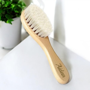 May include: A wooden hair brush with natural bristles and a personalized inscription that reads "Aidan".