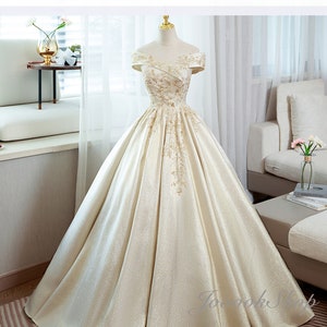 Luxury Golden Applique Beads Bridal Gowns Gorgeous Champagne Wedding Dress Off the Shoulder Sparkle Ball Gown Custom Shiny Satin Floor Dress