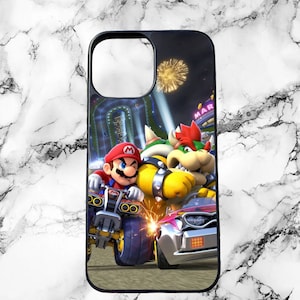 May include: Black phone case featuring a colorful graphic of Mario Kart characters racing. The design includes Mario, Bowser, and a race car, set against a background of a race track and fireworks.