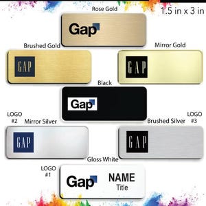 May include: A collection of name badges featuring the Gap logo in different colors and finishes, including rose gold, brushed gold, mirror gold, black, mirror silver, brushed silver, and gloss white. The badges are 1.5 inches by 3 inches and come with a free pin back.