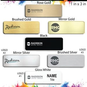 May include: Radisson Hotel name badge design options in various finishes including rose gold, brushed gold, mirror gold, black, mirror silver, brushed silver, and gloss white. The badges are 1 inch by 3 inches and feature the Radisson Hotel Group logo.
