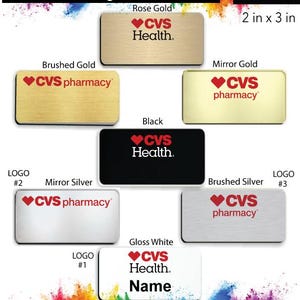 May include: A collection of CVS name badges in various colors and finishes, including rose gold, brushed gold, mirror gold, black, mirror silver, and brushed silver. The badges are 2 inches by 3 inches and feature the CVS logo with the words "CVS Health" or "CVS pharmacy".