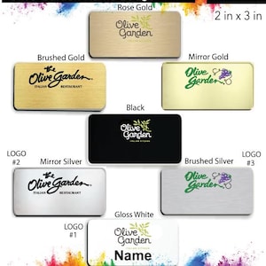May include: A promotional image showcasing various Olive Garden name badges. The badges come in different colors, including brushed gold, mirror gold, black, mirror silver, and gloss white. Each badge is rectangular, measuring 2 inches by 3 inches, and features the Olive Garden logo and text.