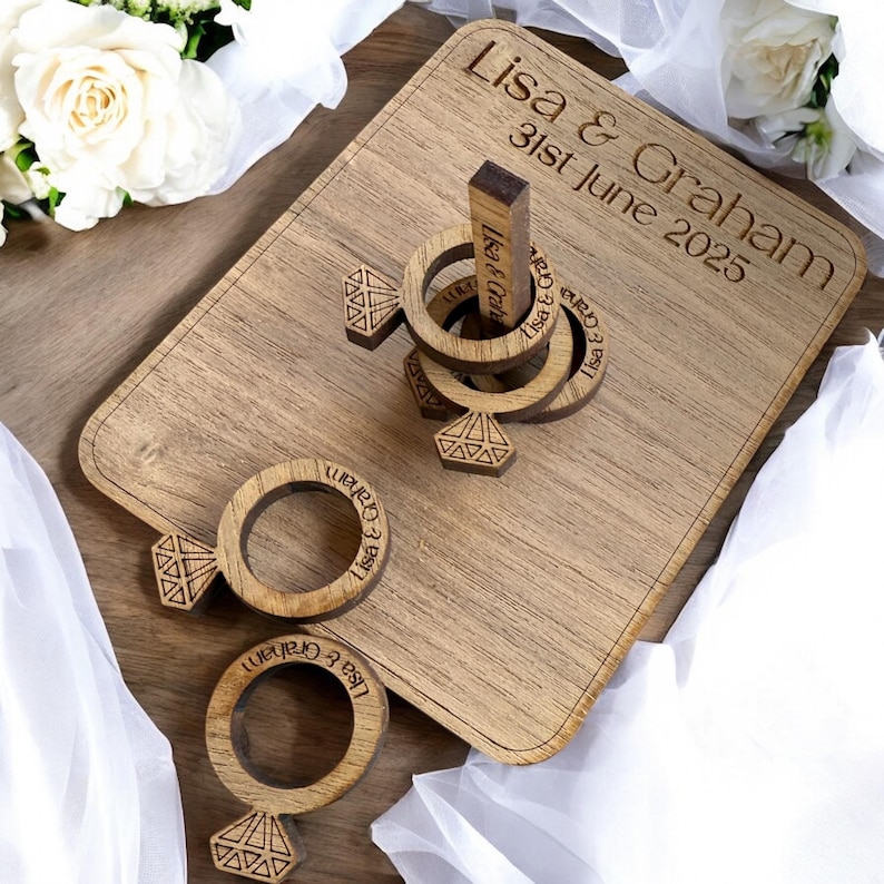 Puede incluir: Juego de lanzamiento de anillos de madera con una inscripci&oacute;n personalizada para una boda. La inscripci&oacute;n dice "Lisa & Graham 31st June 2025".