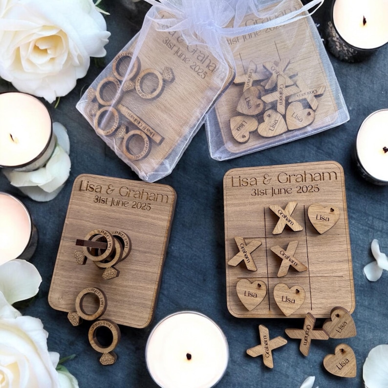 Puede incluir: Dos juegos de boda de madera con nombres personalizados y fecha de boda. Un juego es un rompecabezas de anillos y el otro es un juego de tres en raya con corazones y X.