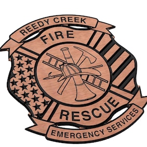 May include: A wooden fire department emblem with a brown background and black lettering. The emblem features a fire helmet, axe, ladder, and a trumpet. The text reads "Reedy Creek Fire Rescue Emergency Services".