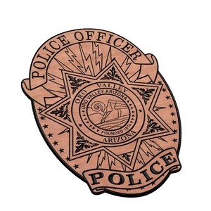 May include: A brown wooden police badge with a black star and the text "Police Officer" and "Police" on a scroll. The star has the text "Oro Valley Arizona" and "Founded 1974" inside.