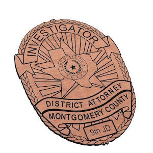May include: A wooden investigator badge with the text "INVESTIGATOR" at the top. The badge features the Texas state seal and the words "DISTRICT ATTORNEY MONTGOMERY COUNTY" and "9th JD".