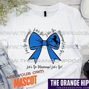 May include: White t-shirt with a blue bow and the text "Let's Go Mustangs! Let's Go!"  The text is repeated in a circle around the bow.  The words "Add Your Own Mascot" are at the bottom of the shirt.