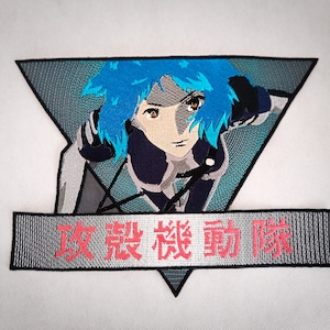 May include: Embroidered patch featuring a blue-haired anime character with a determined expression, set against a gray and blue triangular background. The text "攻殻機動隊" is embroidered in red on a gray banner.