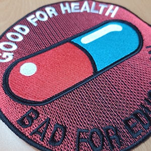 May include: A red and blue pill with the text "Good for Health Bad for Education" around the edge. The pill is on a black and red background.