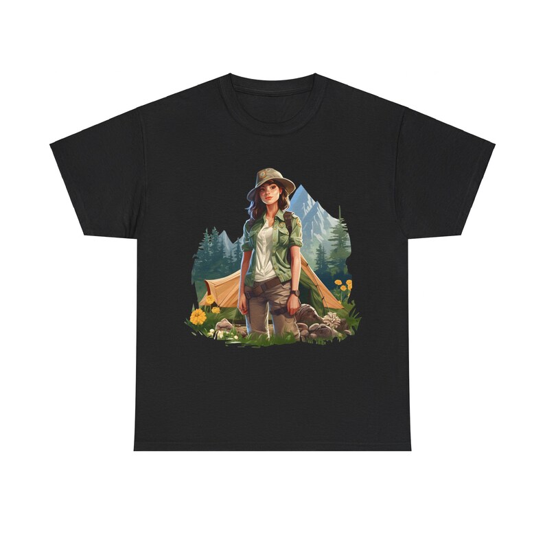 May include: A black t-shirt with a graphic of a woman in a forest setting. She is wearing a green shirt, khaki pants, and a hat. She is standing near a tent and some trees.